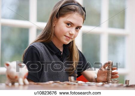 Girl with piggy bank and coins View Large Photo Image Stock Photograph - Girl with piggy bank and coins. Fotosearch