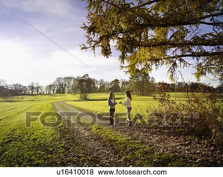 Girlfriends enjoying autumn landscape View Large Photo Image Stock Photo - Girlfriends enjoying autumn landscape. Fotosearch