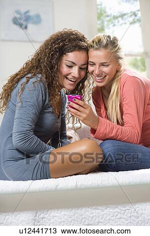 Girlfriends share text on cell phone View Large Photo Image Stock Image - Girlfriends share text on cell phone. Fotosearch