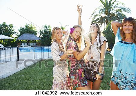 Girls celebrating with drinks by pool View Large Photo Image Stock Image - Girls celebrating with drinks by pool. Fotosearch