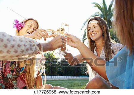Stock Photo - Girls celebrating with drinks by pool. Fotosearch
