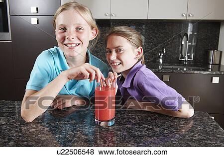 Girls drinking fruit juice with straws View Large Photo Image Stock Photo - Girls drinking fruit juice with straws. Fotosearch
