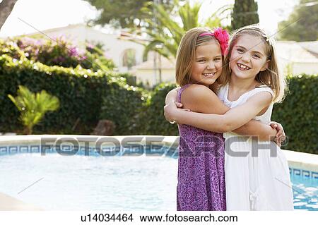 Girls hugging each other by pool View Large Photo Image Picture - Girls hugging each other by pool. Fotosearch
