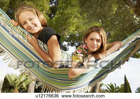 Stock Photograph - Girls lying in hammock. Fotosearch