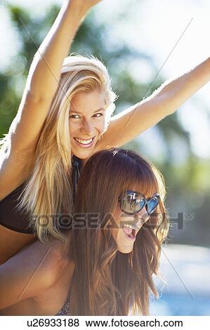 Stock Photo - Girls playing by swimming pool. Fotosearch