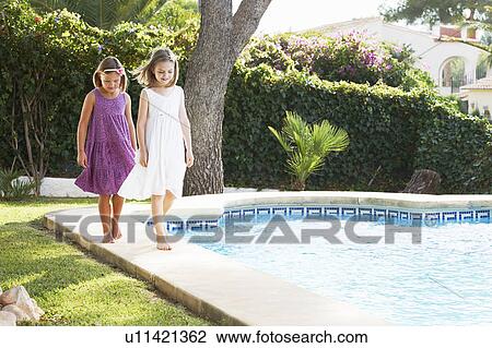 Stock Image - Girls playing by the pool. Fotosearch