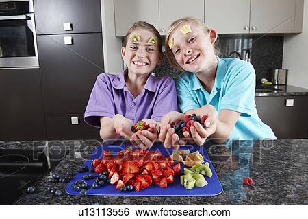 Girls playing with fruit View Large Photo Image Stock Photograph - Girls playing with fruit. Fotosearch