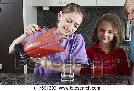 Girls pouring fruit juice from blender View Large Photo Image Stock Photo - Girls pouring fruit juice from blender. Fotosearch