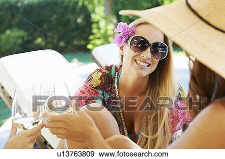 Girls relaxing by the pool on sun beds View Large Photo Image Stock Photo - Girls relaxing by the pool on sun beds. Fotosearch