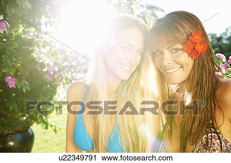 Girls relaxing smiling by the pool View Large Photo Image Stock Image - Girls relaxing smiling by the pool. Fotosearch