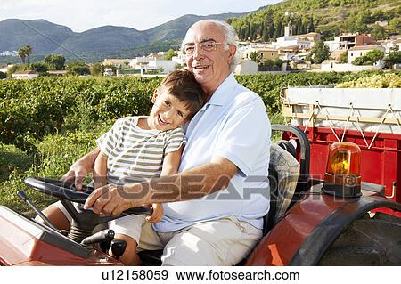Grandfather and boy sitting on tractor View Large Photo Image Stock Photo - Grandfather and boy sitting on tractor. Fotosearch