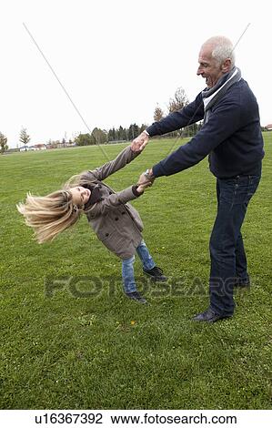 Stock Image - Grandfather and granddaughter in park. Fotosearch