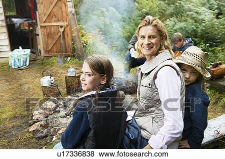 Stock Photo - Grandparents and children by camp fire. Fotosearch