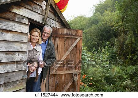Picture - Grandparents and girl hiding in shed. Fotosearch