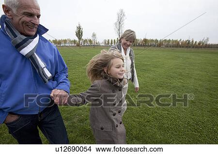 Picture - Grandparents and granddaughter in park. Fotosearch