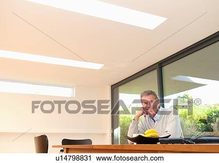 Stock Image - Happy business man at desk. Fotosearch