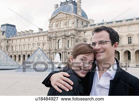 Stock Photo - Happy couple embrace outside the Louvre. Fotosearch