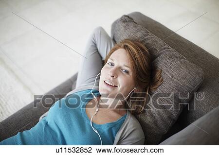 Happy girl lying on sofa with headphones View Large Photo Image Stock Image - Happy girl lying on sofa with headphones. Fotosearch