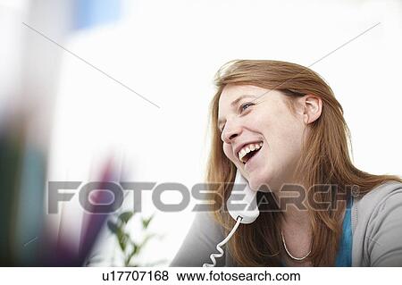 Stock Photo - Happy girl on telephone at desk. Fotosearch