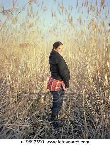 Stock Image - Happy pregnant woman in countryside. Fotosearch
