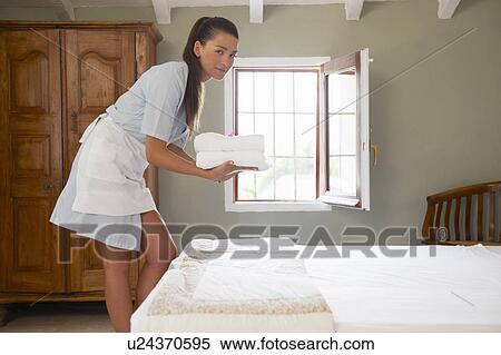 Hotel maid in room with pile of towels View Large Photo Image Stock Photography - Hotel maid in room with pile of towels. Fotosearch