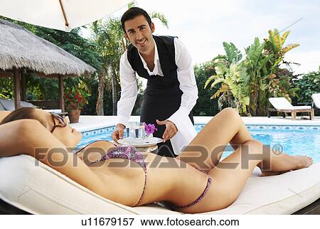 Stock Photo - Hotel waiter serving drinks by the pool. Fotosearch