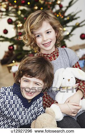 Kids laughing in front of xmas tree View Large Photo Image Stock Photograph - Kids laughing in front of xmas tree. Fotosearch