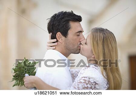 Stock Image - Kissing bridal couple. Fotosearch