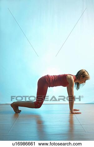 Stock Image - Lady doing yoga in a studio. Fotosearch