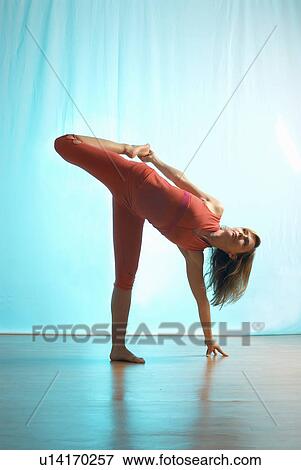Stock Photo - Lady doing yoga in a studio. Fotosearch