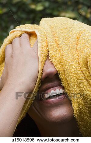 Stock Photograph - Laughing woman drying her, headshot. Fotosearch