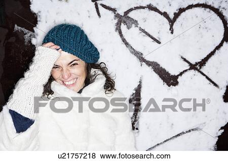 Stock Photo - Laughing woman in front of painted heart. Fotosearch
