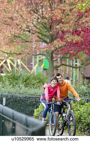Stock Photography - Man and woman cycling in the park. Fotosearch