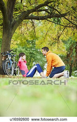 Stock Image - Man and woman exercising in the park. Fotosearch