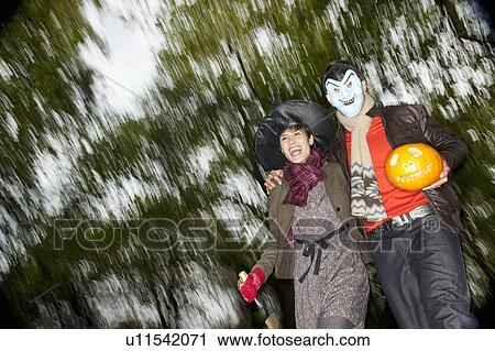 Stock Image - Man and woman going to halloween party. Fotosearch