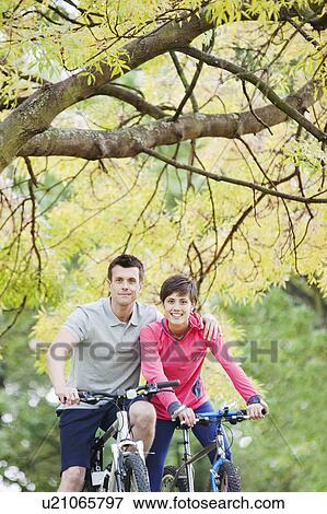 Stock Photo - Man and woman in the park for a cycle. Fotosearch