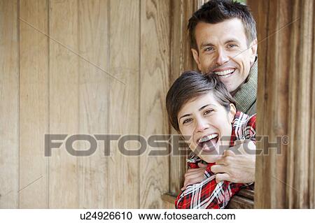 Man and woman laughing in window of hut View Large Photo Image Stock Image - Man and woman laughing in window of hut. Fotosearch
