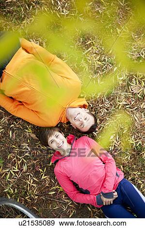 Man and woman lying on grass in the park View Large Photo Image Stock Photo - Man and woman lying on grass in the park. Fotosearch
