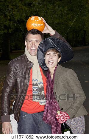 Man and woman with pumpkin on halloween View Large Photo Image Stock Image - Man and woman with pumpkin on halloween. Fotosearch