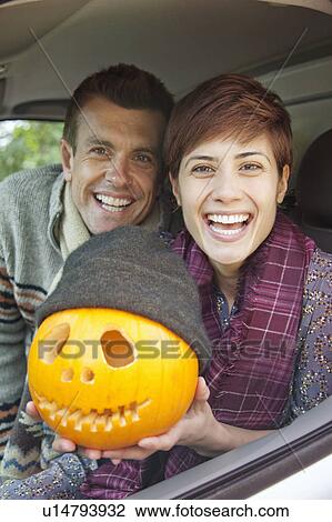 Stock Image - Man and woman with pumpkin on halloween. Fotosearch