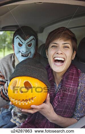 Man and woman with pumpkin on halloween View Large Photo Image Stock Image - Man and woman with pumpkin on halloween. Fotosearch