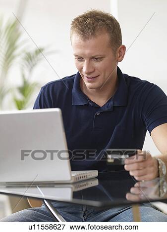 Stock Photo - Man at home shopping online. Fotosearch
