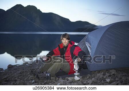 Man camping in mountains on lake View Large Photo Image Picture - Man camping in mountains on lake. Fotosearch
