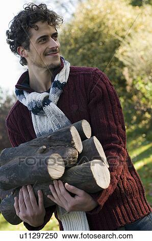 Man carrying logs View Large Photo Image Stock Image - Man carrying logs. Fotosearch