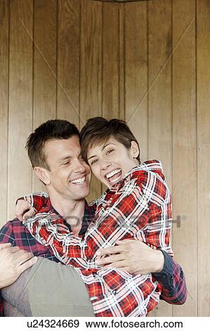 Stock Photo - Man carrying woman in hut in the park. Fotosearch