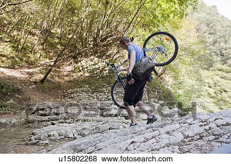 Man crossing a stream with bike View Large Photo Image Stock Photo - Man crossing a stream with bike. Fotosearch