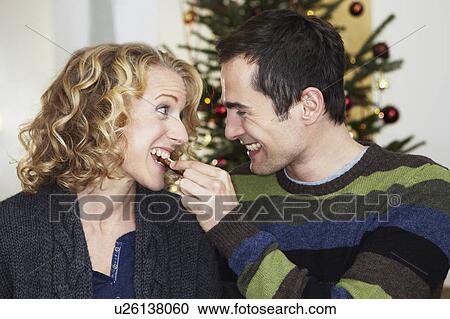 Man feeding woman with cookie View Large Photo Image Stock Image - Man feeding woman with cookie. Fotosearch