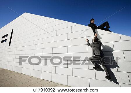 Man helping other man over wall View Large Photo Image Stock Image - Man helping other man over wall. Fotosearch