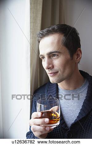 Man holding glass of whiskey View Large Photo Image Stock Image - Man holding glass of whiskey. Fotosearch