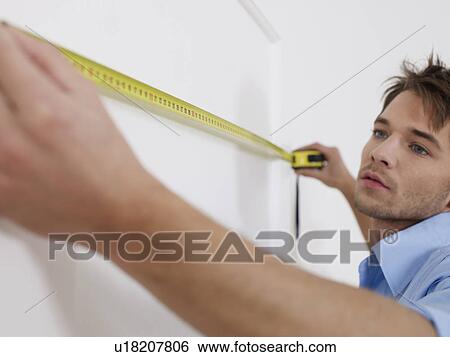 Man is concentrating while measuring View Large Photo Image Stock Photograph - Man is concentrating while measuring. Fotosearch
